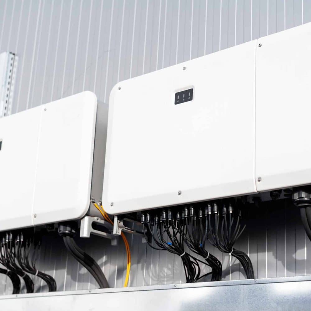 Close view of supporting systems for solar panels located on a manufacturing building , lots of connected wires. Ecology thematics